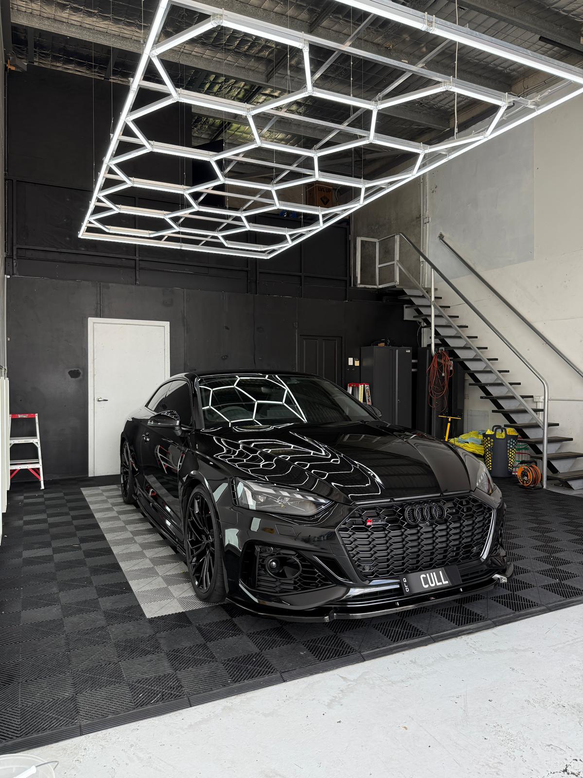 Black Audi RS5 'CULL' in the A1 Auto Styling workshop, hexagonal LED ceiling reflected on the bonnet after a 10-Year ceramic coating
