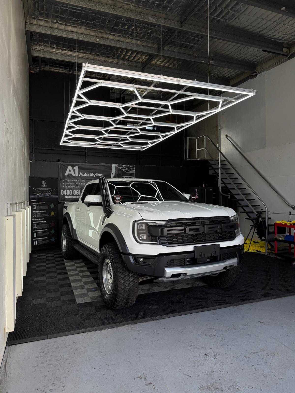 White Ford Ranger Raptor in the A1 Auto Styling workshop after ceramic coating and ceramic tint, hexagonal LED ceiling above